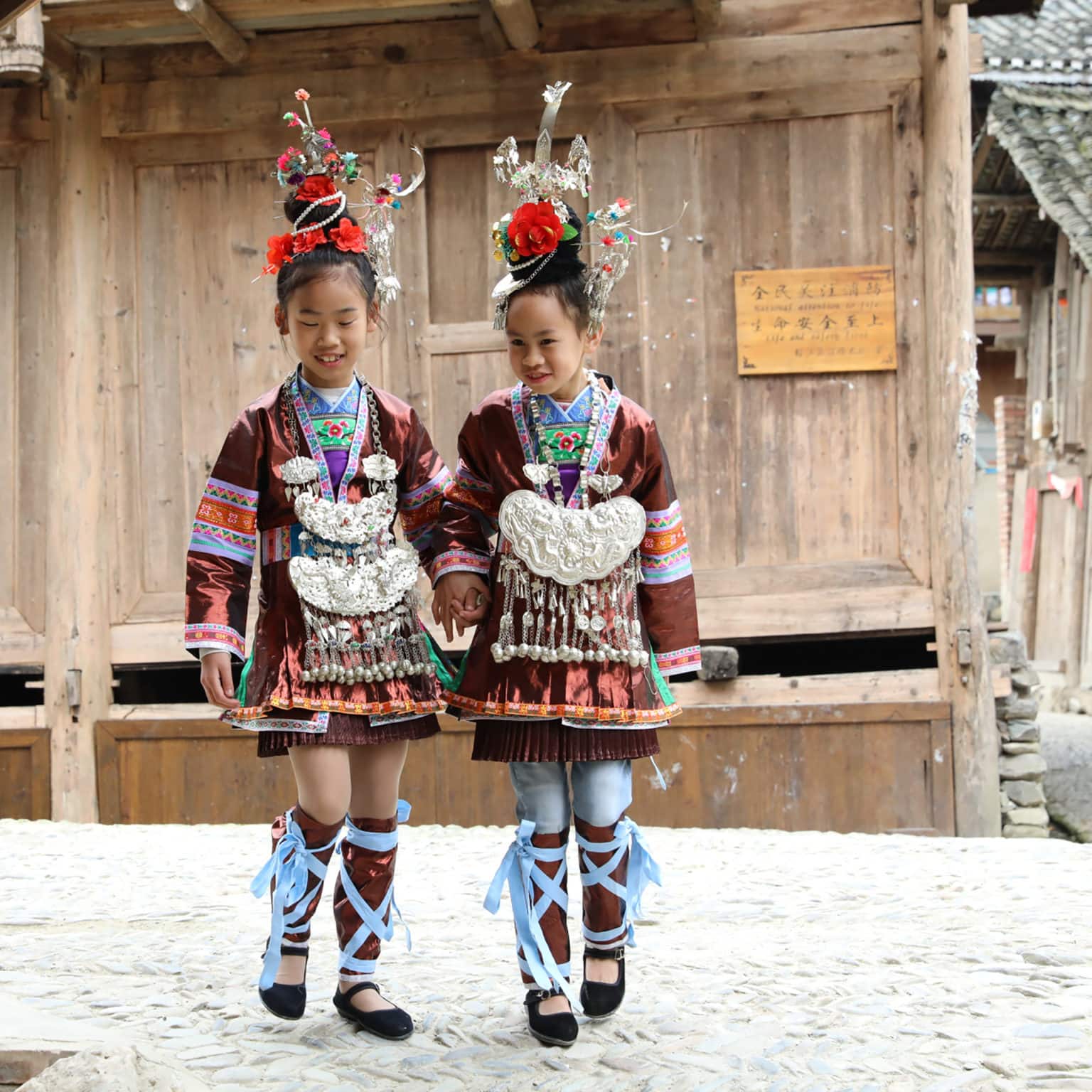 <p>Dali Village is located in Guizhou, a culturally rich but economically poor province in China’s mountainous west. With no industry and few tourists, Dali is experiencing a problem common to many ethnic villages in China’s hinterlands: to support their families, Dali’s residents must leave the village to find work, but by leaving, they slowly weaken the cultural bedrock that brings them home. To create new economic opportunities in Dali that would allow residents to stay and work full time, GHF has partnered with Studio Atlas to found a textile co-op for Dali’s women. Here two local girls wear traditional dress in Dali.<br />
— Photo by Zhang Li/Global Heritage Fund</p>
